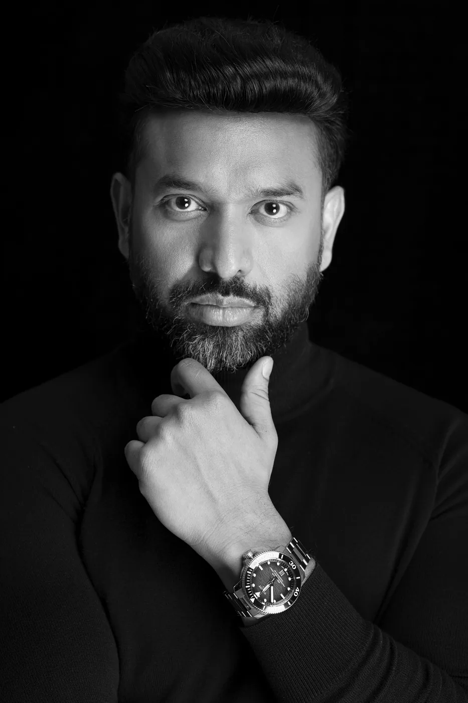 Studio portrait of Ashwani Kumar in a cream knit polo
